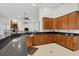 Spacious kitchen featuring dark countertops and wood cabinets, with an open view to the living room at 11008 Nest Ct, Odessa, FL 33556