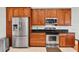 Kitchen features stainless steel appliances, wood cabinets, and tile flooring at 11008 Nest Ct, Odessa, FL 33556