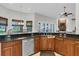 Large kitchen with granite countertops, stainless steel dishwasher, and a view to the fireplace at 11008 Nest Ct, Odessa, FL 33556