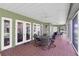 Lanai with brick floors, a dining table with chairs, and multiple doorways to the home's interior at 11008 Nest Ct, Odessa, FL 33556