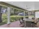 Screened lanai featuring brick floors, ceiling fans, a dining table, and views of the expansive backyard at 11008 Nest Ct, Odessa, FL 33556