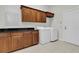 Laundry room with wood cabinets, black countertops, washer, dryer, and tiled floors at 11008 Nest Ct, Odessa, FL 33556