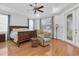 Bright main bedroom with ceiling fan, wood floors, a lounge chair and french doors to the outside at 11008 Nest Ct, Odessa, FL 33556