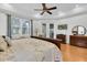 Comfortable main bedroom featuring a ceiling fan, tv, and a door leading to the backyard patio at 11008 Nest Ct, Odessa, FL 33556
