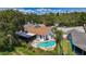 Aerial view of the home showcasing its pool, screened lanai, and well-manicured yard at 11362 Heritage Way, Largo, FL 33778