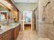 Bathroom with custom tile work, granite counters, glass shower, and bedroom access at 11362 Heritage Way, Largo, FL 33778