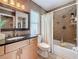 Modern bathroom featuring granite countertops, dark tile, and shower with tub at 11362 Heritage Way, Largo, FL 33778
