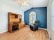 Bright bedroom featuring hardwood floors, desk with hutch, and comfortable chair at 11362 Heritage Way, Largo, FL 33778