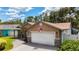 Charming single-Gathering home with a two car garage, green lawn, and an American flag at 11362 Heritage Way, Largo, FL 33778