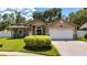 Charming single Gathering home with an attached two car garage, manicured lawn, and American flag at 11362 Heritage Way, Largo, FL 33778
