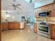 Spacious kitchen with stainless steel appliances, custom cabinets, and a view of the living area at 11362 Heritage Way, Largo, FL 33778