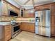 Well-appointed kitchen featuring stainless steel appliances, custom cabinetry, and granite countertops at 11362 Heritage Way, Largo, FL 33778