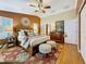 Warm bedroom featuring hardwood floors, ceiling fan, rug and ensuite access at 11362 Heritage Way, Largo, FL 33778