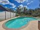 Sparkling pool and spa surrounded by a white fence and lush landscaping at 11362 Heritage Way, Largo, FL 33778