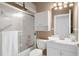 Bright bathroom with a white vanity, toilet, and shower/tub with a sliding glass door at 11439 Golf Round Dr, New Port Richey, FL 34654