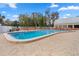 Sparkling community pool with ample seating, shaded umbrellas, and a pristine pool deck at 11439 Golf Round Dr, New Port Richey, FL 34654