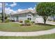 Side view of a home with light green exterior and a manicured lawn with a sprinkler system at 11439 Golf Round Dr, New Port Richey, FL 34654