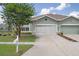 Home exterior featuring a well-kept lawn, mailbox, and a two-car garage with a driveway at 11439 Golf Round Dr, New Port Richey, FL 34654