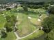 Aerial view of a lush golf course with mature trees, water features, and manicured greens at 11439 Golf Round Dr, New Port Richey, FL 34654