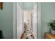 Hallway leading to bathroom with green walls and closet with bi-fold doors at 11439 Golf Round Dr, New Port Richey, FL 34654