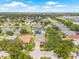 Aerial view showcasing a beautiful home in a neighborhood near a lake, surrounded by lush trees at 11830 Autumn Creek Dr, Riverview, FL 33569