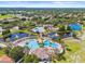 An aerial view showcases a community pool, tennis courts, and lush greenery, perfect for active living at 11830 Autumn Creek Dr, Riverview, FL 33569