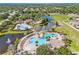 An aerial view showcases a community pool, tennis courts, and lush greenery, perfect for active living at 11830 Autumn Creek Dr, Riverview, FL 33569