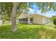 Expansive backyard featuring a screened lanai, lush lawn and white fence at 11830 Autumn Creek Dr, Riverview, FL 33569