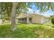 Well-maintained backyard with green lawn, mature trees, and screened porch offers private outdoor space at 11830 Autumn Creek Dr, Riverview, FL 33569