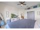 Bright bedroom featuring a ceiling fan, a large dresser with a TV, and convenient access to the kitchen at 11830 Autumn Creek Dr, Riverview, FL 33569