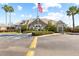 Exterior view of community clubhouse featuring manicured landscaping, an American flag, and ample parking at 11830 Autumn Creek Dr, Riverview, FL 33569