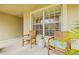 Cozy front porch featuring two wooden chairs with green cushions and decorative potted plants at 11830 Autumn Creek Dr, Riverview, FL 33569