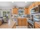 Well-equipped kitchen with wood cabinets, stainless steel appliances, and natural light from a window at 11830 Autumn Creek Dr, Riverview, FL 33569