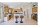 Well-lit kitchen features light wood cabinets, stainless steel appliances, and sleek bar stools at 11830 Autumn Creek Dr, Riverview, FL 33569