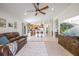 Open concept living area featuring tile flooring, a ceiling fan, and a view of the kitchen with barstool seating at 11830 Autumn Creek Dr, Riverview, FL 33569