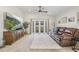 Cozy living room featuring a plush leather sofa, a large-screen TV, and elegant French doors at 11830 Autumn Creek Dr, Riverview, FL 33569