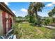 Backyard with a palm tree and a green yard, partially fenced, offering privacy at 1213 Cuttingin Pl, Tampa, FL 33612