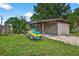 Charming house with well-maintained lawn, mature trees, and a jet ski on a trailer in the front yard at 1213 Cuttingin Pl, Tampa, FL 33612