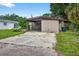 Exterior view of the house with a jet ski on trailer in driveway, showing its curb appeal and convenient parking at 1213 Cuttingin Pl, Tampa, FL 33612