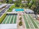 Overhead view of community shuffleboard, tennis courts, and sparkling pool at 12400 Park Blvd # 519, Seminole, FL 33772