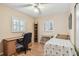 Comfortable bedroom with a desk, wood floors, ceiling fan and windows dressed with white shutters at 12400 Park Blvd # 519, Seminole, FL 33772