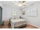 Cozy bedroom with a comfortable bed, light-filled windows with shutters, ceiling fan, and wood flooring at 12400 Park Blvd # 519, Seminole, FL 33772