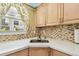 Kitchen area featuring light cabinets, stone backsplash and marble countertops at 12400 Park Blvd # 519, Seminole, FL 33772