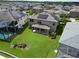 Aerial view of a spacious backyard with a patio, lush green lawn, and solar panels on the roof at 12821 Satin Lily Dr, Riverview, FL 33579