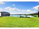 Spacious backyard with a lush lawn, screened-in porch, and picturesque lake view at 12821 Satin Lily Dr, Riverview, FL 33579
