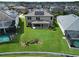 Aerial view showcasing a spacious backyard, patio, lush lawn, and nearby pool enclosures at 12821 Satin Lily Dr, Riverview, FL 33579