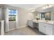 Bright bathroom featuring dual sinks, white cabinetry, and a window for natural light at 12821 Satin Lily Dr, Riverview, FL 33579