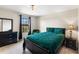 Cozy bedroom with a dark bed frame, green bedding, and black dresser at 12821 Satin Lily Dr, Riverview, FL 33579