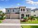 Stunning two-story home featuring a three-car garage and beautifully landscaped front yard at 12821 Satin Lily Dr, Riverview, FL 33579