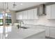 Bright kitchen featuring white cabinets, an island, and modern lighting fixtures at 12821 Satin Lily Dr, Riverview, FL 33579